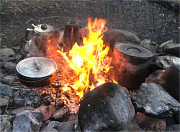 Dutch oven cooking on a campfire.